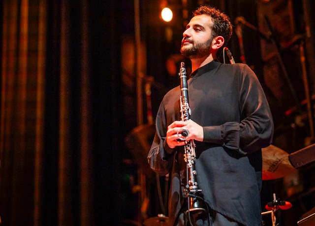 Mehrpouya Daneshvar holding a clarinet on stage