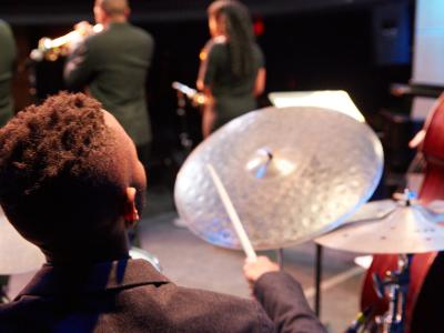 Drummer performing on stage with other musicians