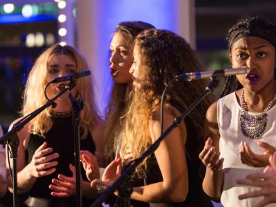 Ensemble of vocalists singing into microphones