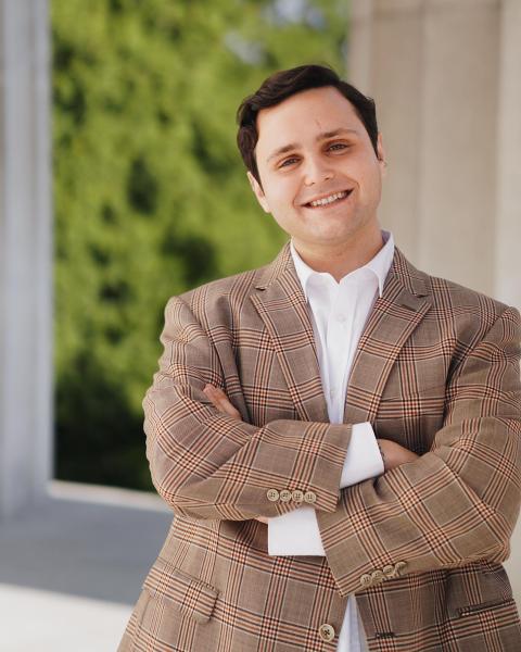 Hyatt Aronoff wearing a suit outside, smiling.