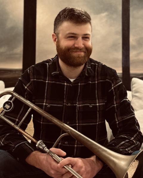 Headshot of Jim Connolly holding trombone