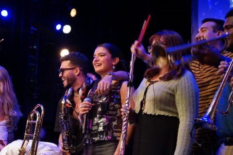 Musicians playing instruments on stage during a live performance.