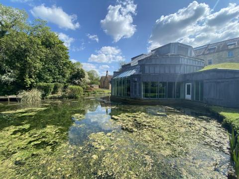 Real World Studios seen from the outside on a sunny day with a verdant pond in the foreground